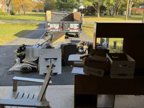 Residential junk removal in Elmira, NY with items staged for a garage cleanout and trailer loading