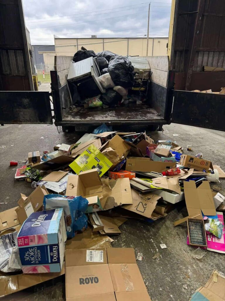 Recyclable materials and trash being sorted during a weekly trash pickup service in Elmira, NY.